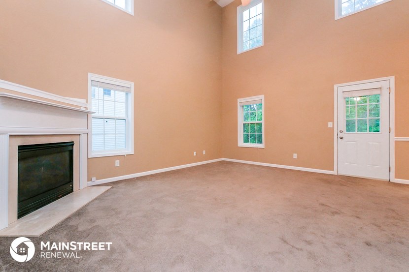 a living room with a fireplace and a carpeted floor