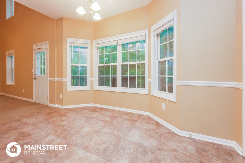 an empty living room with windows and a door