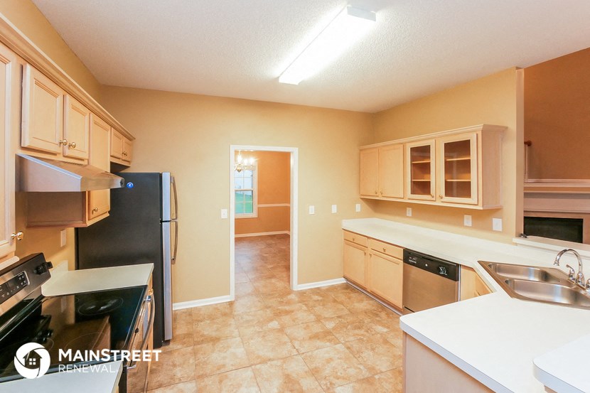 a kitchen with white counter tops and a black refrigerator