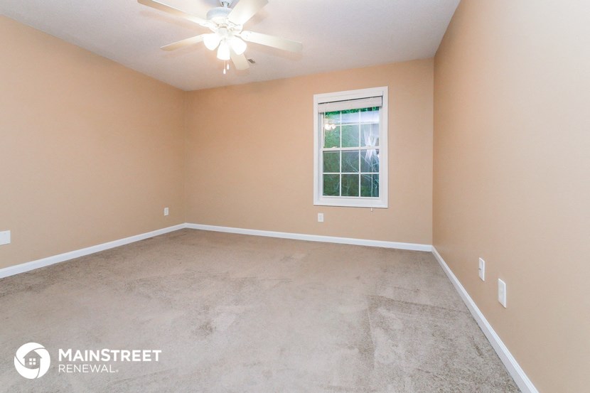 the master bedroom has a concrete floor and a ceiling fan