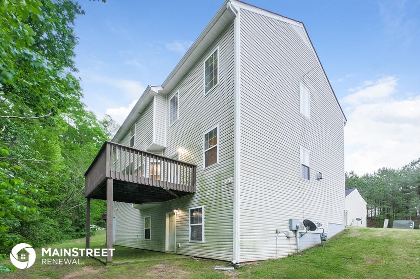 the back of the house with a deck on top of it