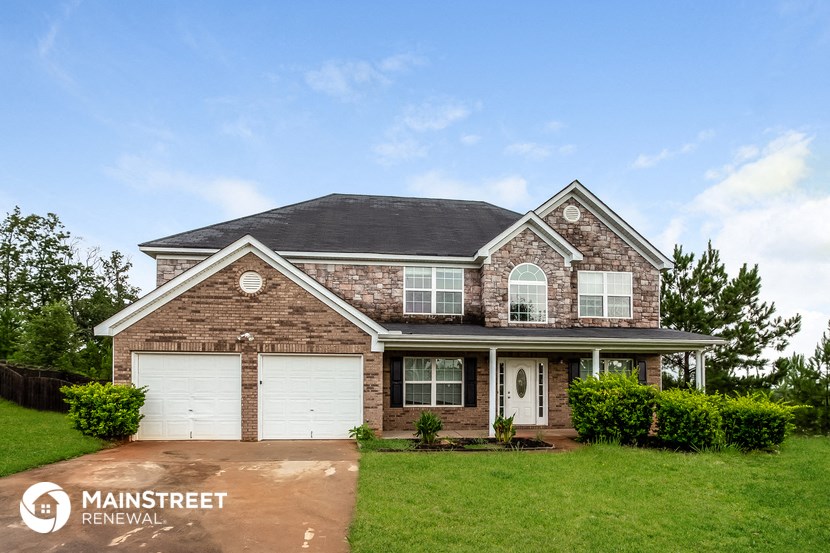 a brick house with two white garage doors