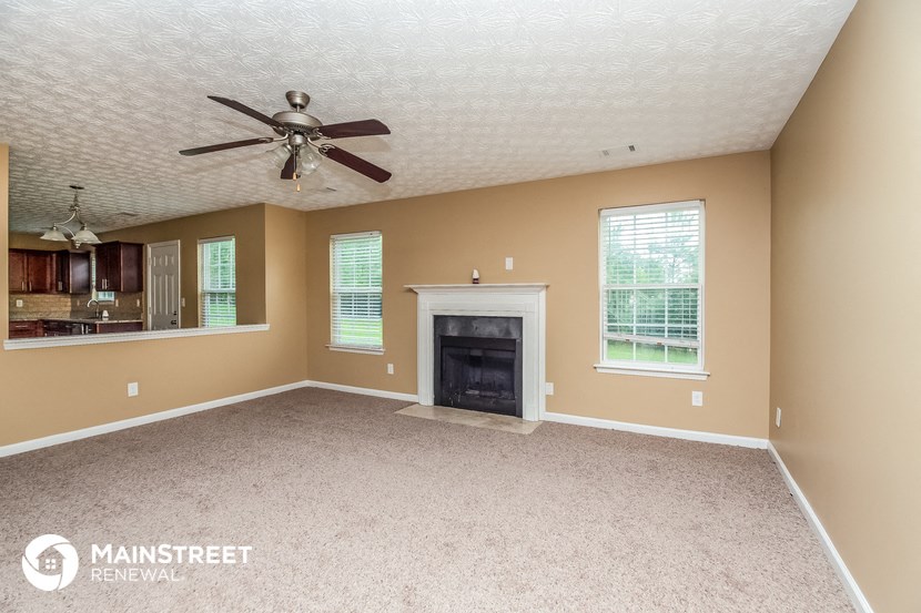 a living room with a fireplace and a ceiling fan