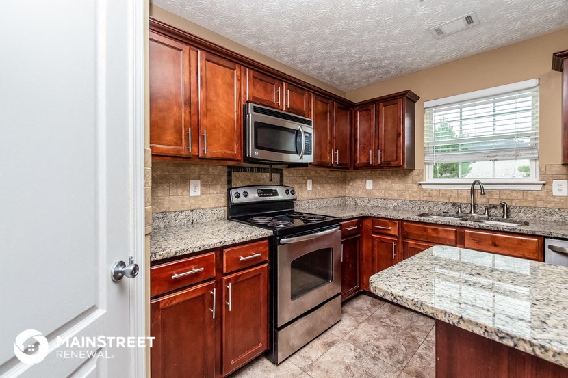 a kitchen with wooden cabinets and stainless steel appliances and granite counter tops