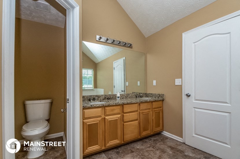 a bathroom with a toilet and a sink and a mirror