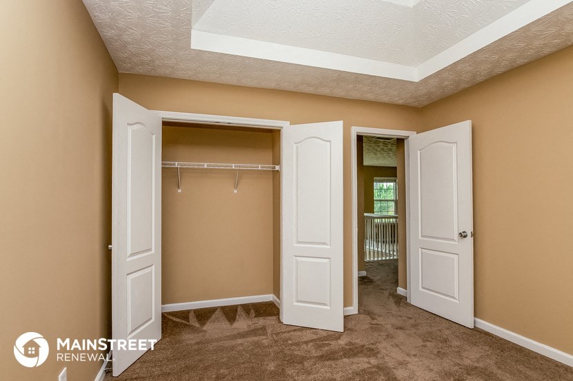 a walk in closet with two doors and a mirrored closet door open to a closet