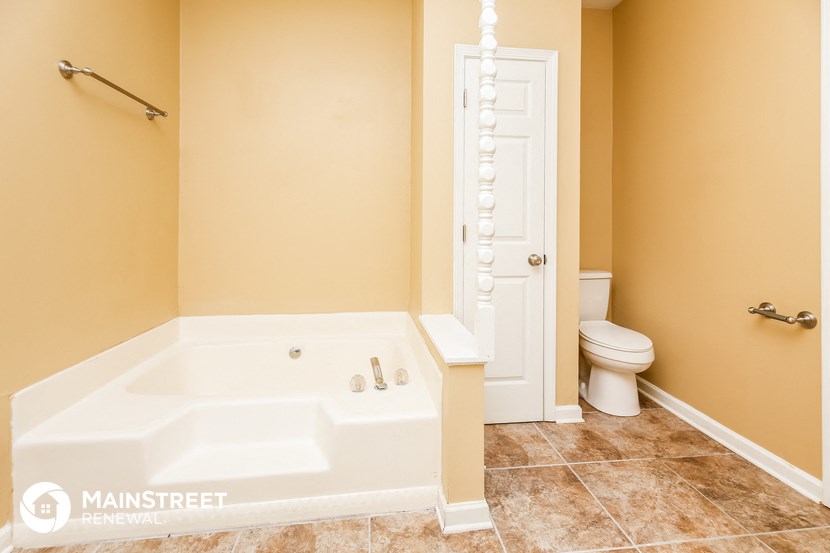 a bathroom with a tub and a toilet and a closet