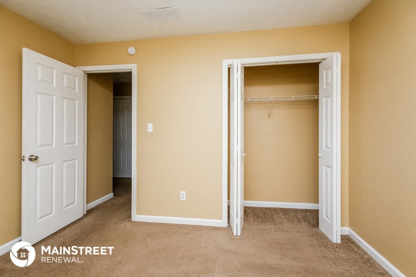 a bedroom with a closet and an open door to a closet