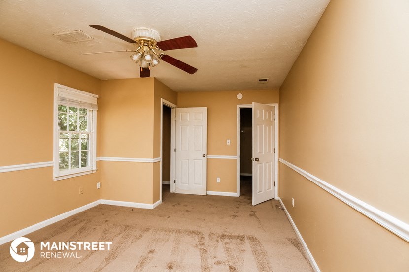 a empty living room with a ceiling fan