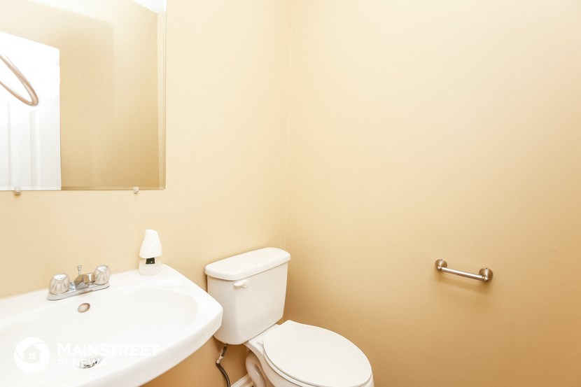 a bathroom with a toilet and a sink and a mirror