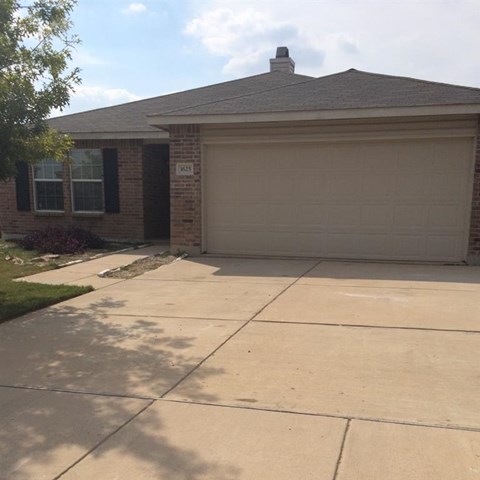 a driveway in front of a house with a garage door