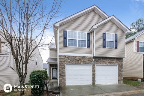 the front of a house with a white garage door