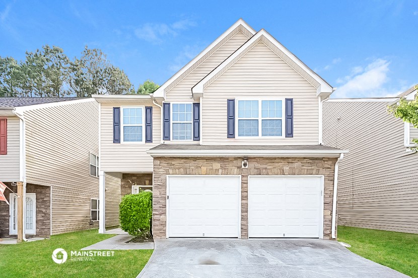 a beige house with two garage doors