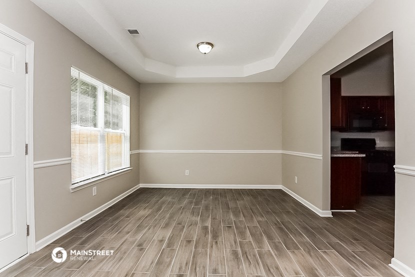 an empty living room with wood floors and a window