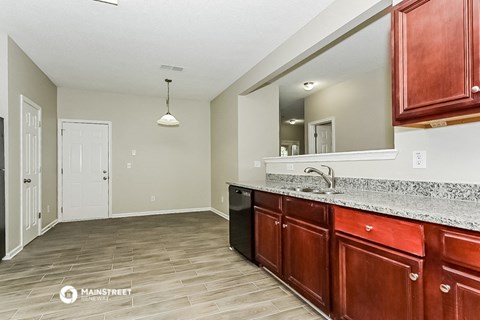 a kitchen with wooden cabinets and a sink and a mirror