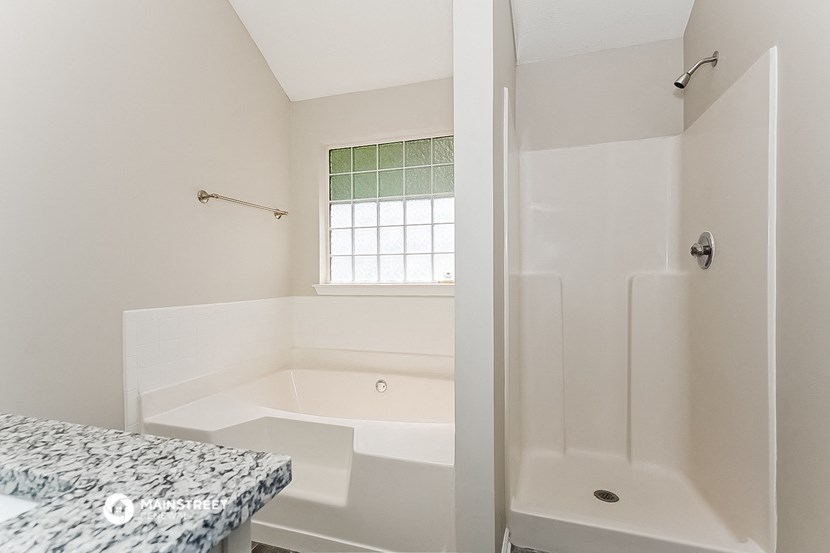 a bathroom with a tub and a shower and a sink