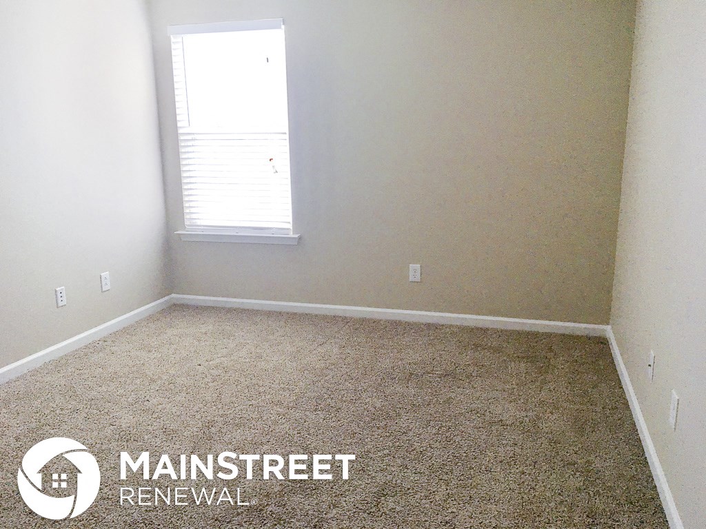 a room with a carpeted floor and a window