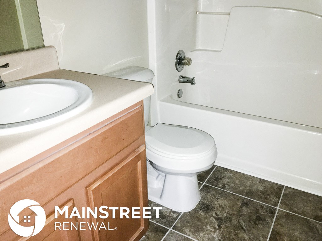 a bathroom with a toilet and a sink and a tub