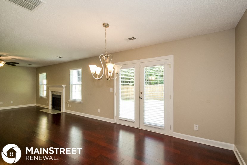 an empty living room with a fireplace and doors