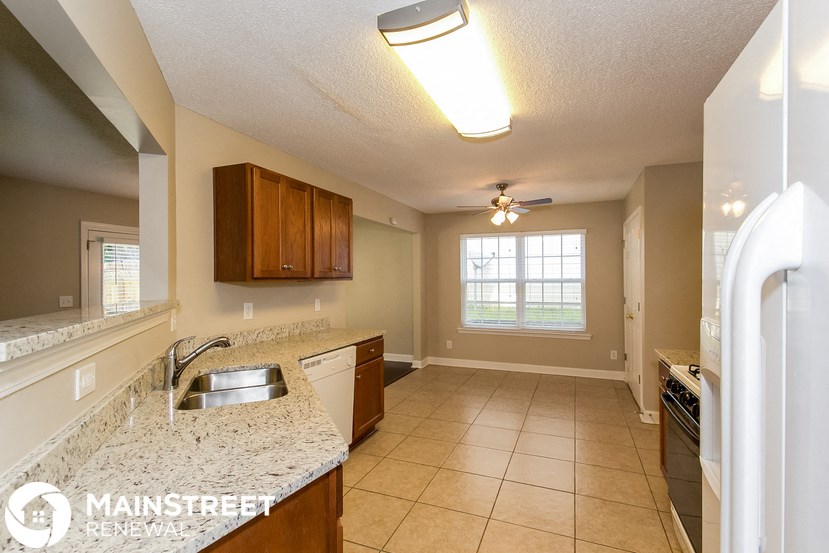 a kitchen with a sink and a ceiling fan