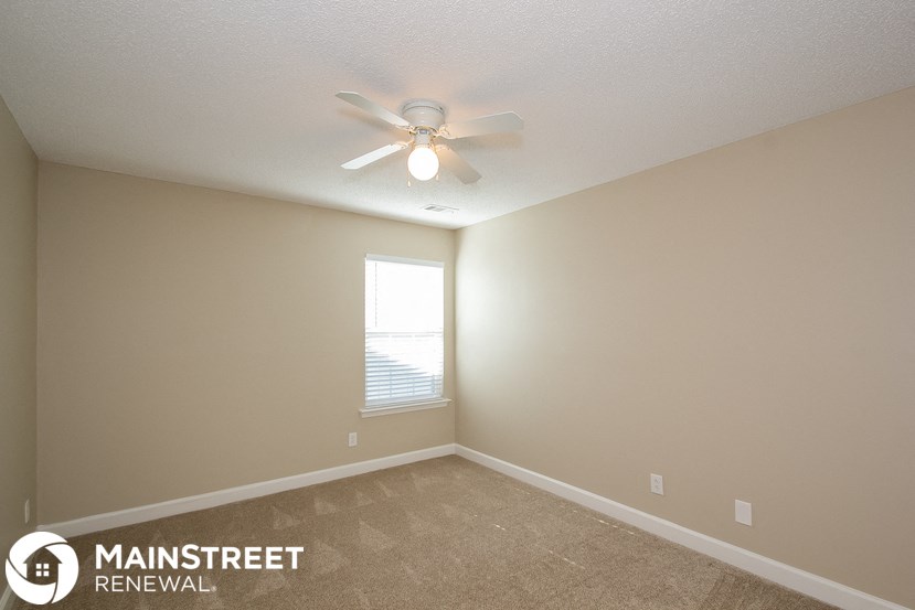 a bedroom with a ceiling fan and a window