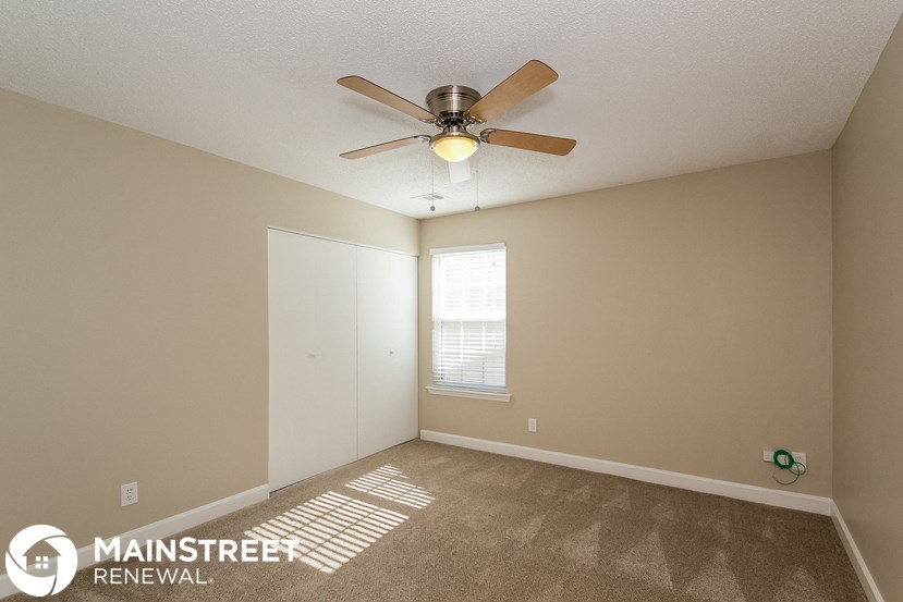 the living room of an empty bedroom with a ceiling fan