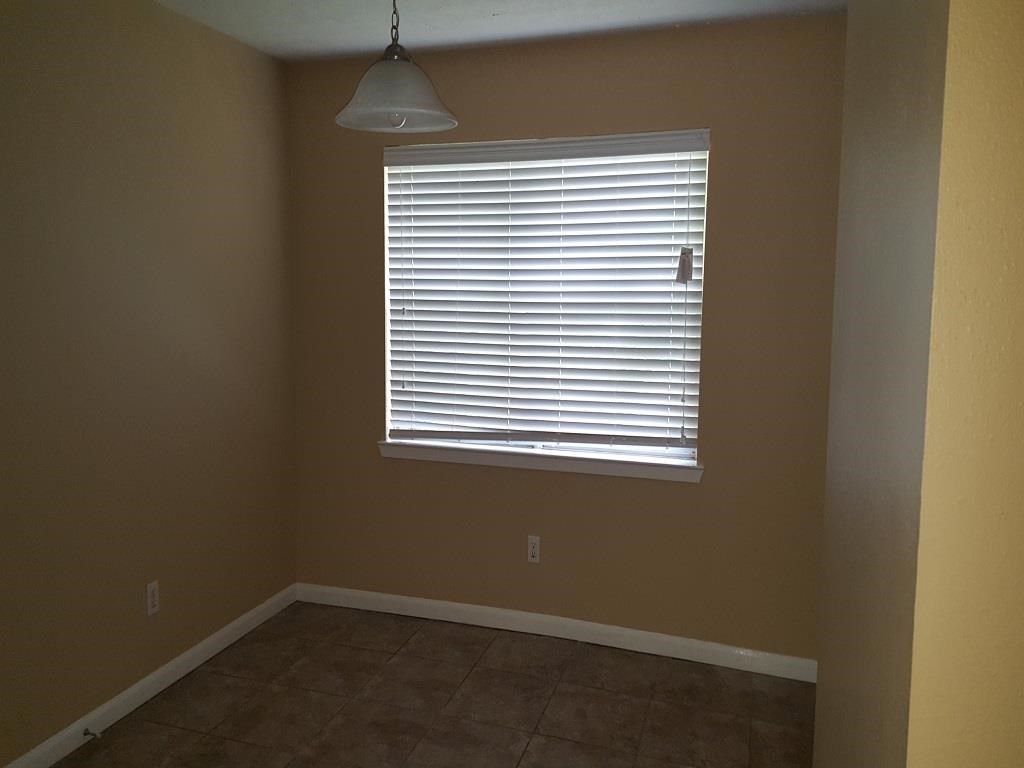 an empty room with a window and a lamp