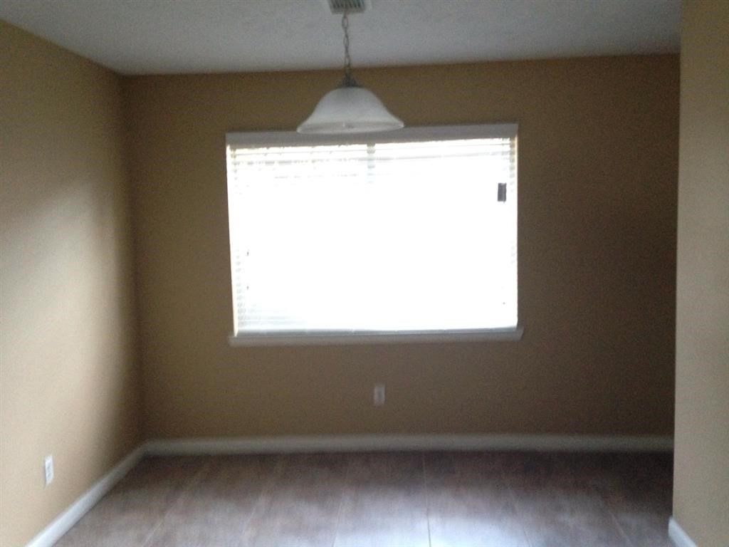 an empty living room with a window and wood floors