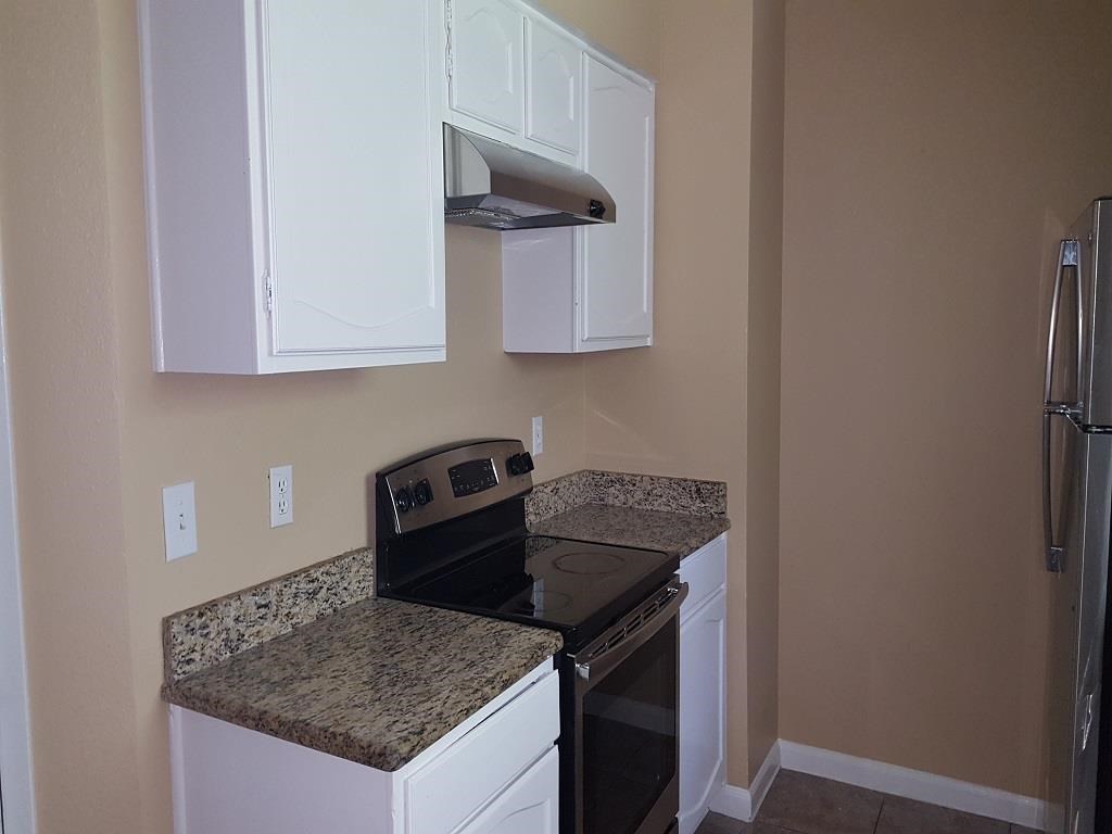 a kitchen with a stove and white cabinets