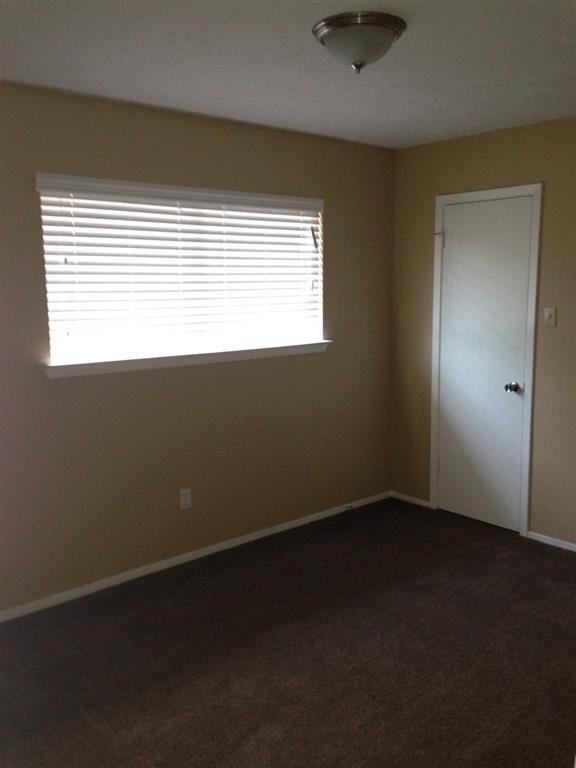 an empty room with a window and a door