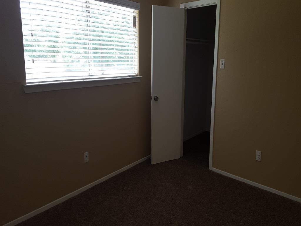 an empty room with a window and a door