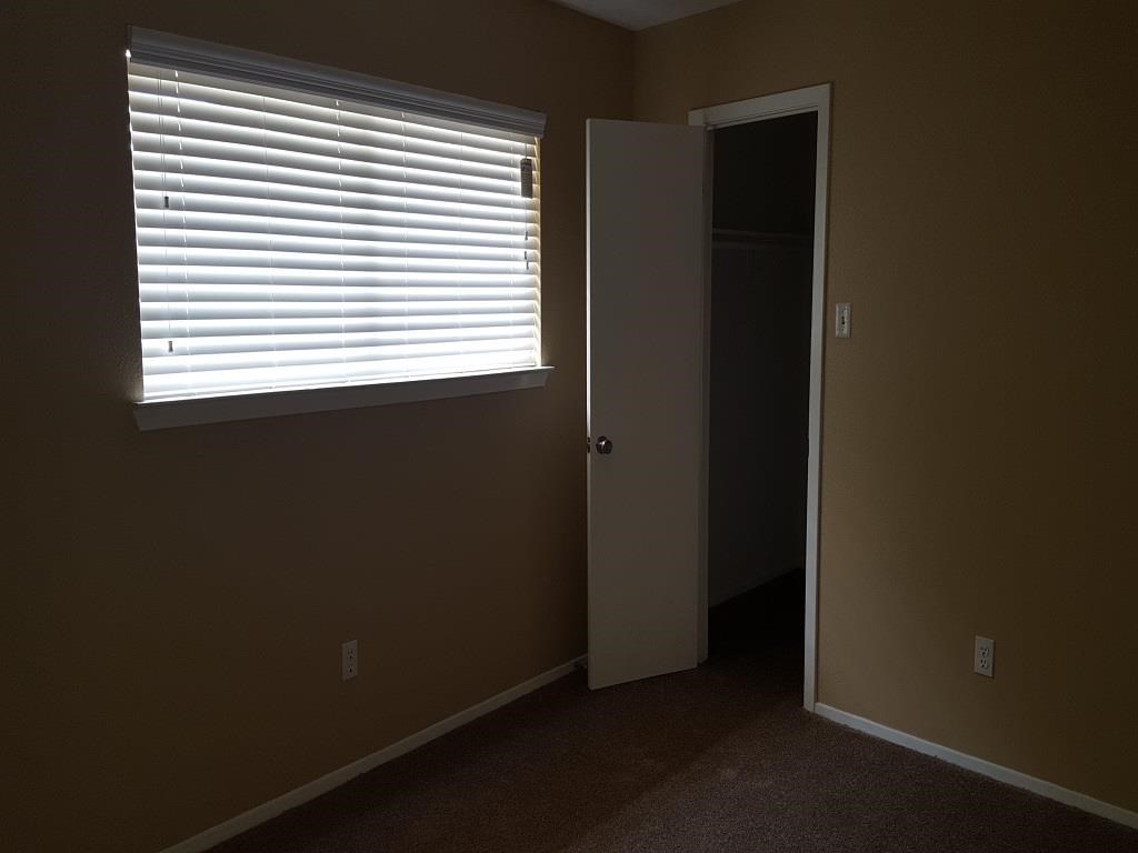 an empty room with a window and a door