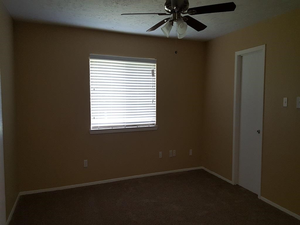 a living room with a ceiling fan and a window