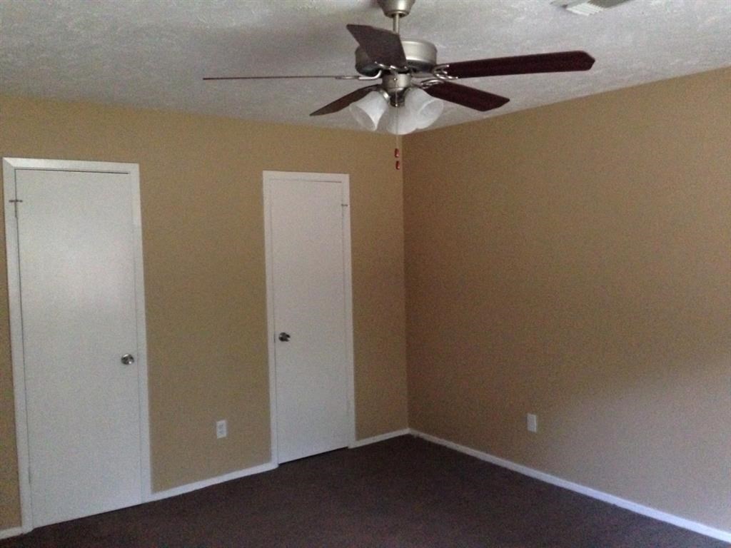 a room with a ceiling fan and two doors