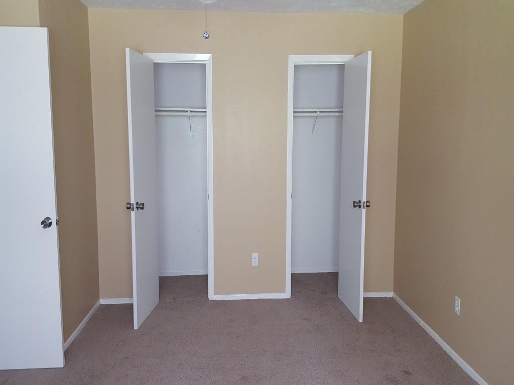 an empty room with three closet doors in it