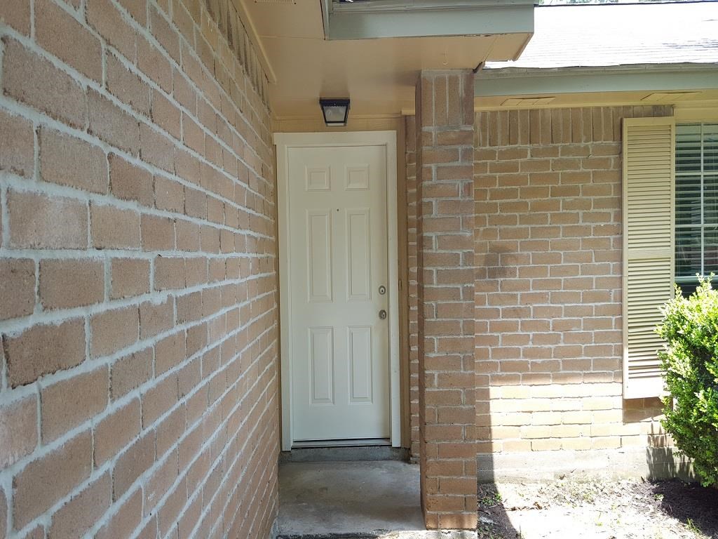 the front door of a brick building with a white door