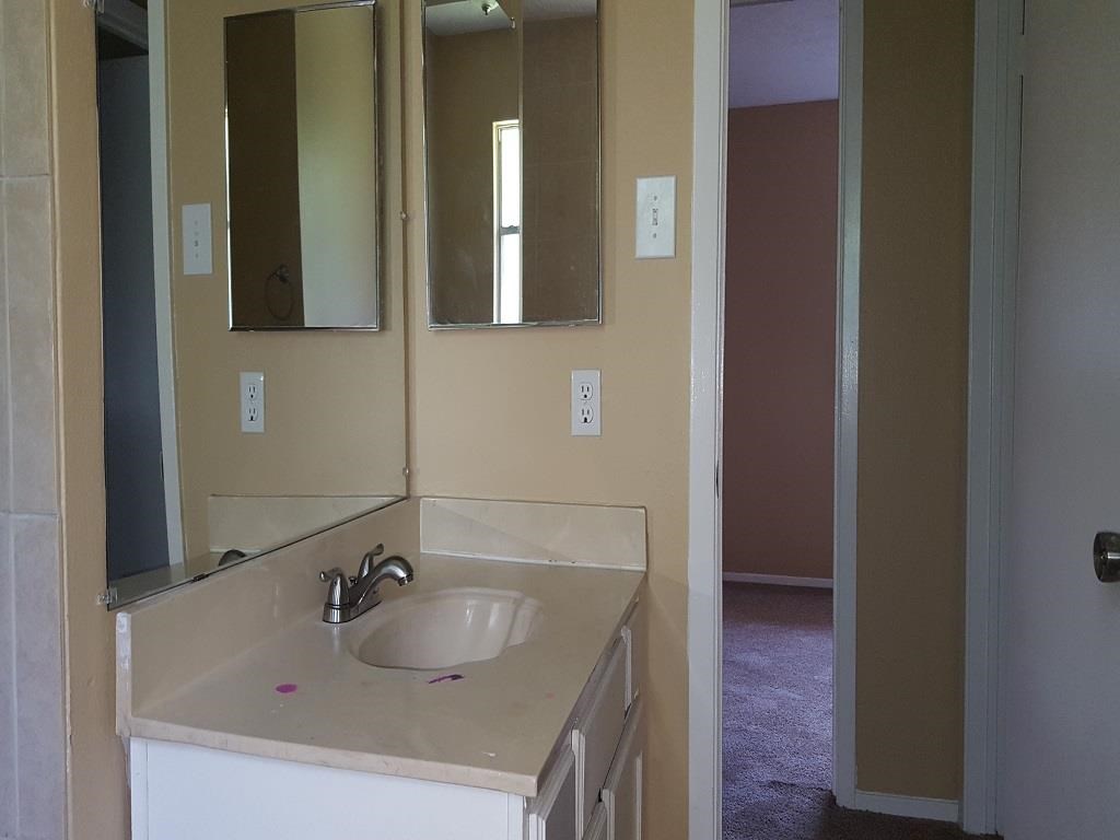 an empty bathroom with a sink and a mirror