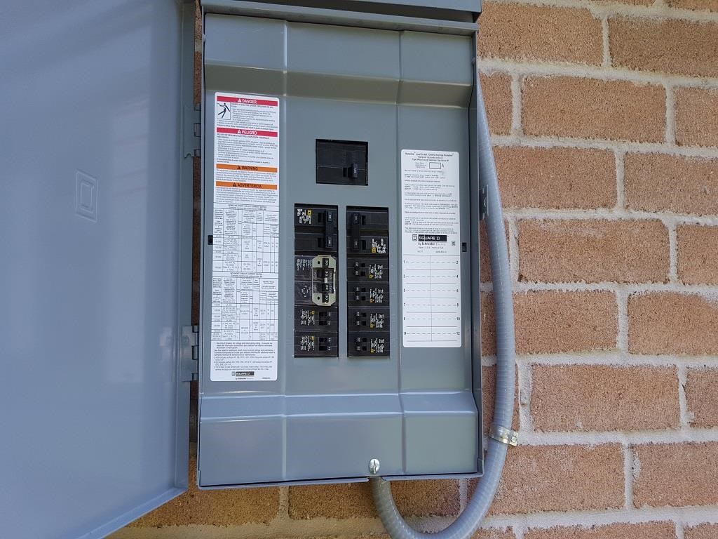 an electrical box with wires plugged into it on a brick wall