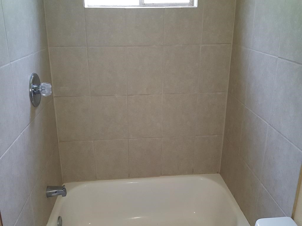 a bathroom with a white bath tub and a window