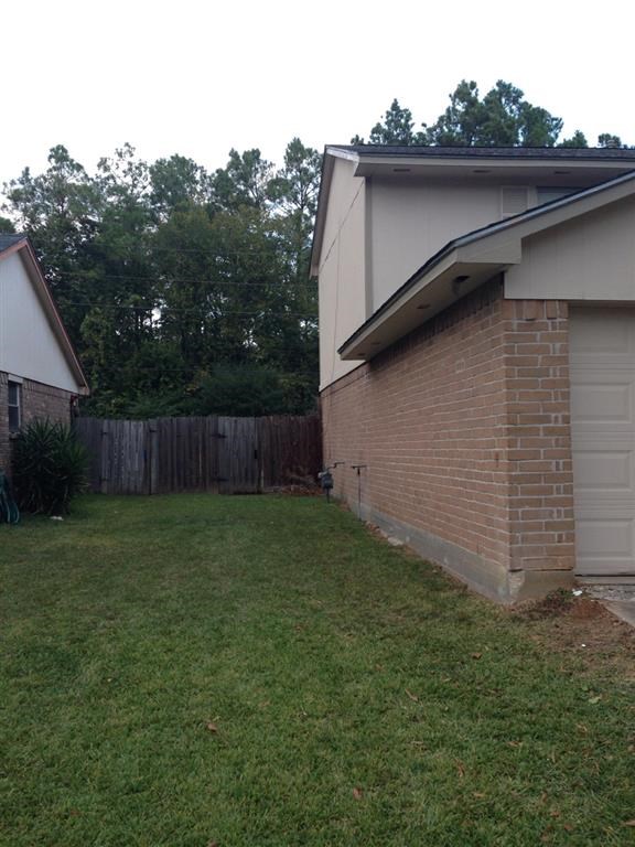 a backyard with a brick house and a fence