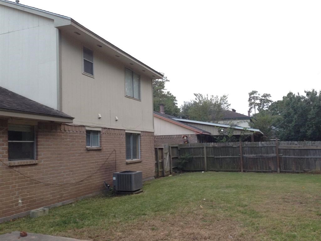 a backyard with a brick house and a wooden fence