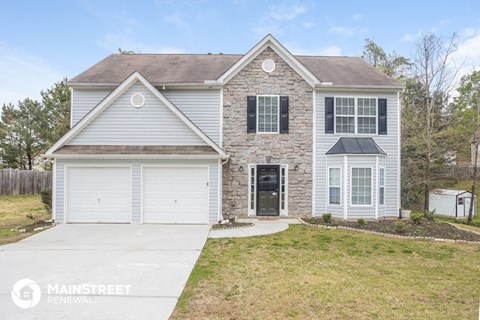 a white and brick house with a white garage door