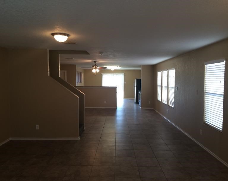 a large empty living room with a tile floor