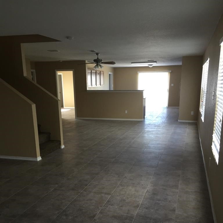 an empty living room with a ceiling fan in it