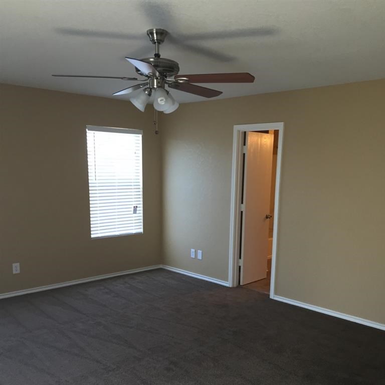 a living room with a ceiling fan and a door