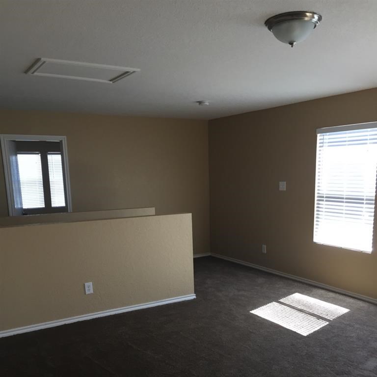 an empty living room with a couch and a window