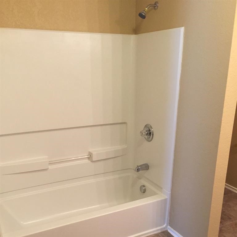 a white bathroom with a tub and a shower