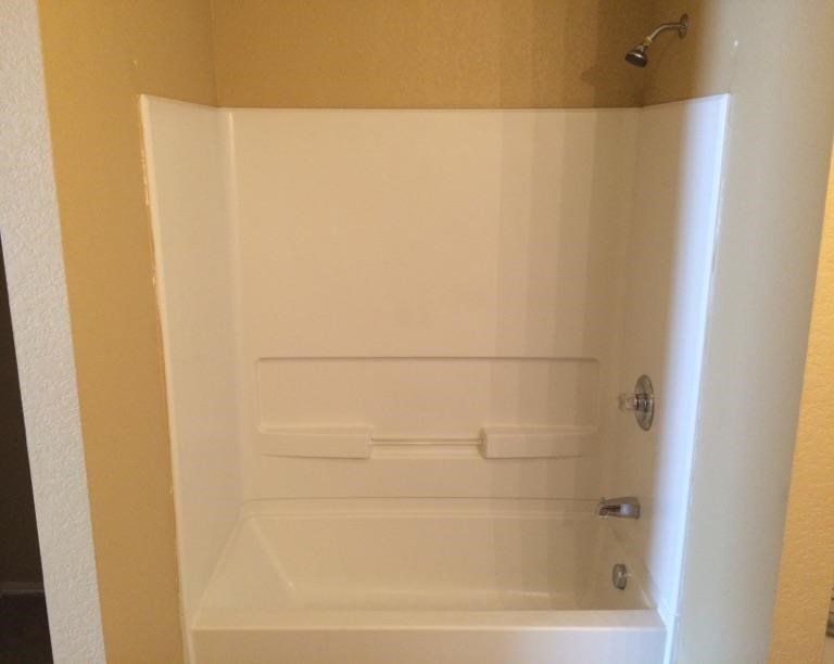 a white bathroom with a shower and a tub