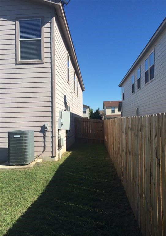a backyard with a house and a wooden fence