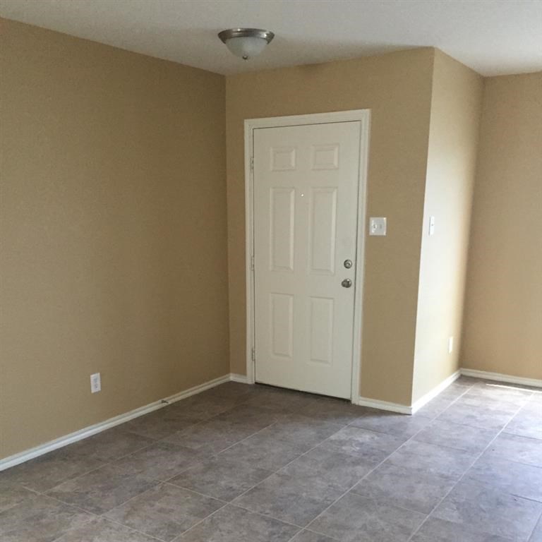 a empty room with a white door and a tile floor